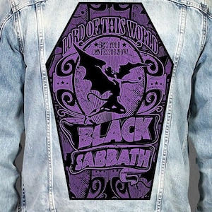 May include: A light blue denim jacket featuring a large, coffin-shaped back patch. The patch displays a purple and black graphic with a winged figure, the text "LORD OF THIS WORLD", "HE'S YOUR CONFESSOR NOW!", and "BLACK SABBATH" in bold lettering.