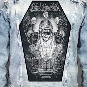 Op de afbeelding: Een lichtblauw spijkerjack met een grote, doodskistvormige zwart-witte rugpatch. De patch toont een bebaarde figuur met een ooglapje, twee raven en de tekst Blind Guardian, Valhalla, Deliverance en andere kleine zinsneden.