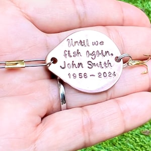 Może przedstawiać: Złota przynęta wędkarska z spersonalizowanym napisem "Until we fish again. John Smith 1956 - 2024".