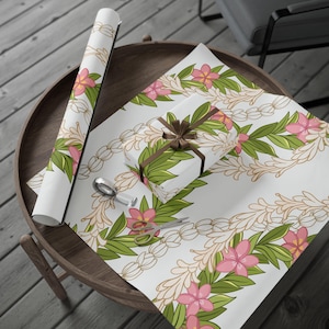 May include: White wrapping paper with a repeating pattern of pink flowers and green leaves. The flowers are arranged in a garland pattern. The paper is rolled up and tied with a brown ribbon.