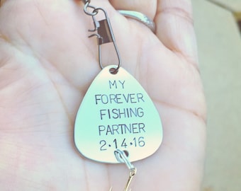 Op de afbeelding: Zilveren vislood met de tekst "My Forever Fishing Partner 2.14.16" erop gegraveerd.
