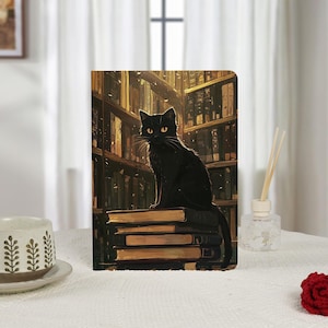May include: A black cat with yellow eyes sits atop a stack of books in front of a library backdrop. The artwork is on a rectangular object, possibly a tablet cover or a decorative panel. The scene is warm-toned with a cozy, inviting atmosphere.