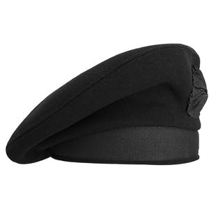 Puede incluir: Un sombrero boina negro con una cinta en la base y un detalle decorativo en el lateral. La boina está hecha de un material suave y es un estilo clásico.