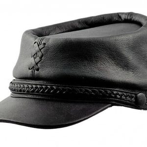 May include: Black leather cap with a short brim and a braided band around the base. The cap features a decorative stitched design on the side and a button closure. The hat is a solid black color.