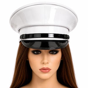 May include: A white, glossy captain's hat with a black visor and band. The hat has a structured, rounded crown and a shiny finish. The hat is a fashion accessory.