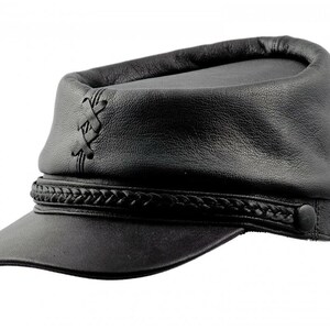 May include: Black leather cap with a short brim and a braided band. The cap features decorative stitching on the side and a button detail. The hat has a classic, military-inspired design.