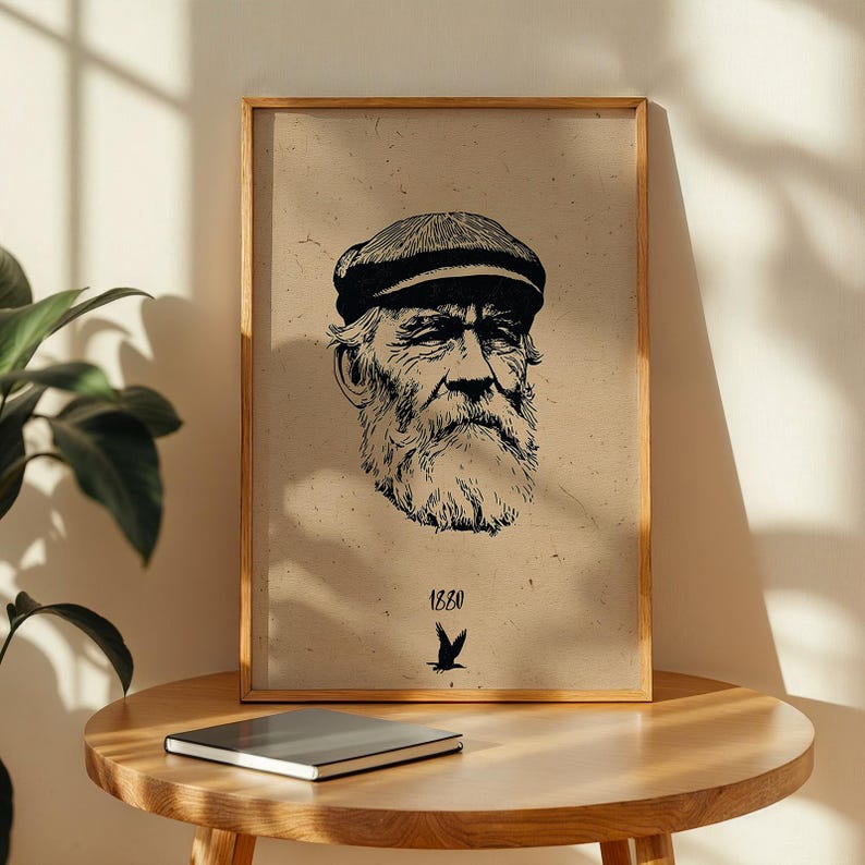 May include: A framed print featuring a detailed black and white illustration of an elderly man with a full beard and cap. The print includes the year "1880" and a bird graphic. The artwork is displayed on a wooden table.