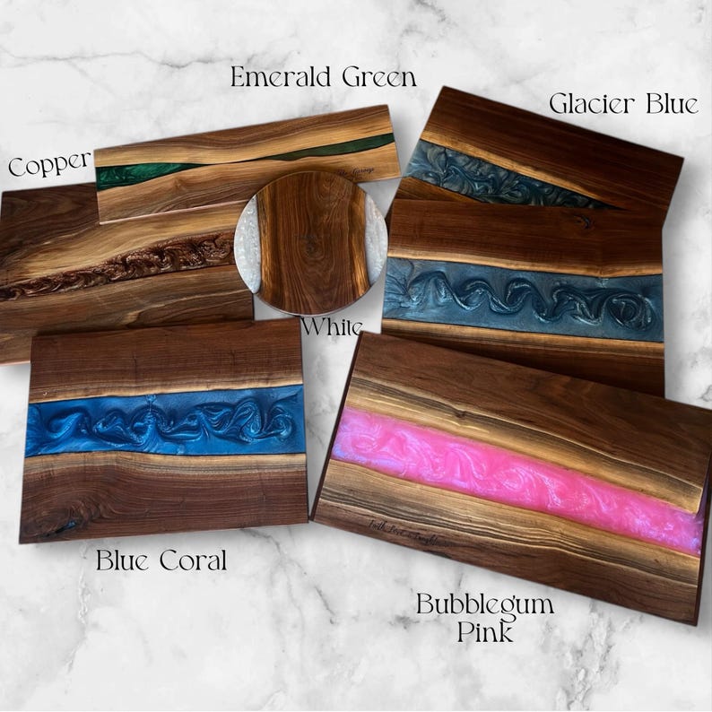 May include: Five different cutting boards made of wood with a resin inlay. The boards are in various colors, including emerald green, glacier blue, white, blue coral, and bubblegum pink.