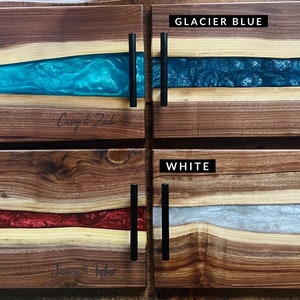 May include: Four wooden serving trays with epoxy resin inlays. The trays are in turquoise, glacier blue, merlot, and white. Each tray has a personalized inscription.