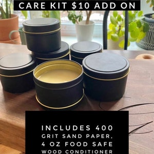 May include: A wood conditioning care kit with four small black tins with gold lids, containing 4 ounces of food safe wood conditioner. The kit also includes 400 grit sandpaper and care instructions to keep your board looking and feeling fresh.