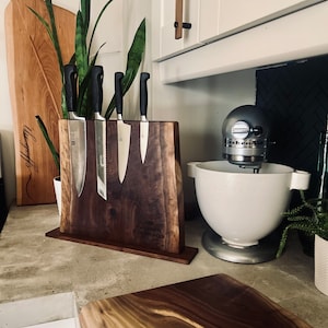 May include: A wooden knife block with a live edge design, holding a set of four kitchen knives. The block is engraved with the text "Palmer Colorado" and "Est. 1982".