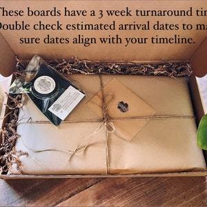 May include: A brown cardboard box with a brown paper wrapped package inside. The box is open and the package is visible. The package is tied with twine and has a small brown envelope on top. The box is filled with brown packing peanuts.