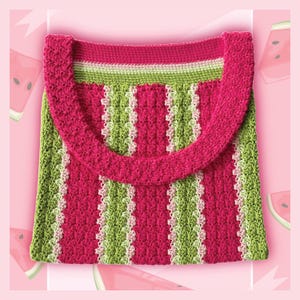 Puede incluir: Un bolso tote de crochet hecho a mano con un diseño de sandía. El bolso presenta rayas verticales alternas de color rosa brillante y verde, con un acento blanco. El asa y el borde superior son de color rosa liso. El bolso está sobre un fondo rosa con rodajas de sandía.