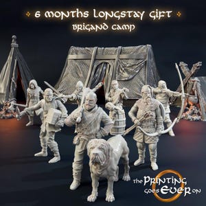 May include: A detailed model of a medieval camp scene, featuring several warrior figurines, a dog, and tents. The text "6 months longstay gift brigand camp" is displayed above. The Printing Goes Ever On logo is at the bottom.