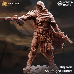 May include: A brown miniature figure of a Soulforged Hunter, holding two firearms. The figure is wearing a hooded cloak and armour. The text "DM STASH PRINT.PAINT.PLAY" and "A WILD HUNT" are visible. The figure is labelled "Big Iron Soulforged Hunter".