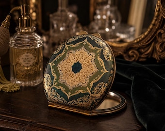 Specchietto da trucco Art Déco antico in pelle verde con decorazioni dorate in rilievo.