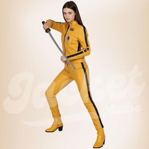 Könnte beinhalten: Gelber Leder-Overall mit schwarzen Streifen an den Seiten und Ärmeln. Das Outfit umfasst eine passende Jacke und Hose und wird mit gelben Stiefeln kombiniert. Die Person hält ein Katana-Schwert.