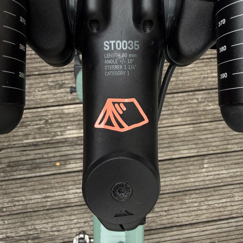Fahrrad Sticker „Zeltmotiv“ – Vinyl-Aufkleber in Orange auf Lenker, minimalistisches Design für Bikepacking-Fans
