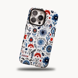 May include: A white phone case with a colorful floral pattern. The design features blue, red, and black flowers and foliage. The case has a black border around the camera and a white background.