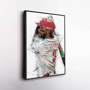May include: Framed art print of a baseball player in a red helmet and white jersey with the name "HARPER" and the number "3" on the back. The artwork has a watercolor effect with paint splatters and the word "zoom" on the helmet.
