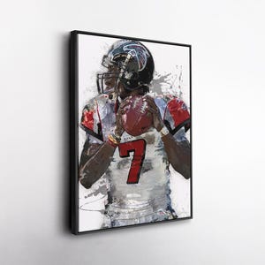 May include: Framed artwork of a football player in a helmet, holding a football. The player is wearing a jersey with the number 7 in red. The artwork has a watercolor effect with splashes of color.