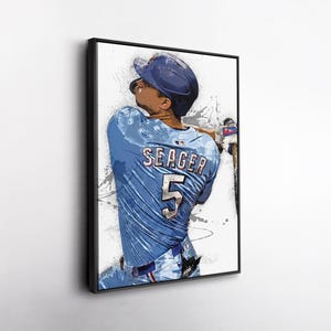May include: Framed art print of a baseball player in a blue uniform with the name "SEAGER" and the number "5" on the back. The artwork has a watercolor effect with splashes of color and a black frame.