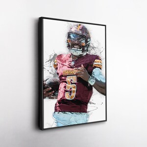 May include: Framed artwork of a football player in a burgundy and gold uniform, helmet, and pads. The jersey displays the number 5 in gold. The player is holding a football. The background has a white and grey splatter effect.