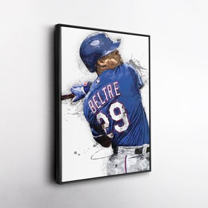 May include: A framed art print of a baseball player in a blue uniform with the name "BELTRE" and the number "29" on the back. The artwork has a watercolor effect with blue, white, and gray paint splatters, set against a white background.