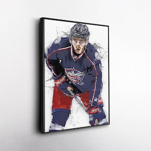 May include: Framed art print of a hockey player in a blue and red uniform, with a helmet and gloves. The player is in a ready stance, holding a hockey stick. The artwork has a watercolor effect with white paint splatters.