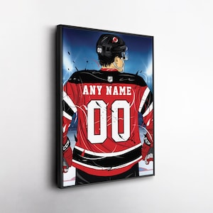 May include: Framed artwork of a hockey player from the back, wearing a red and black jersey with the number "00" and the text "ANY NAME". The player is wearing a black helmet and is on the ice.