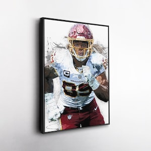 May include: Framed artwork of a football player in a burgundy and white uniform, helmet, and pads. The player is in a dynamic pose, with a determined expression. The artwork has a watercolor-like effect, with splashes of colour.