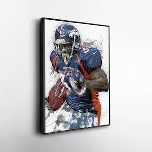 May include: Framed watercolor-style print of a football player in a blue and orange uniform, holding a football. The player is wearing a helmet with a horse logo. The background has gray paint splatters.