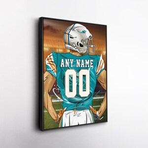 May include: Framed artwork of a football player in a teal and orange jersey with the text "ANY NAME" above the number "00". The player is wearing a white helmet with a team logo. The background shows a stadium with orange and brown tones.