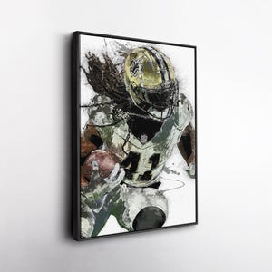 May include: Framed artwork of a football player in a Saints uniform, number 41, running with the ball. The player is wearing a gold helmet. The artwork has a watercolor effect with black and white accents.
