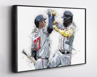 May include: Baseball-themed artwork featuring two players in action, high-fiving. The players wear white and red uniforms with the number 27 visible. The artwork has a watercolor effect with a black frame.