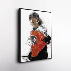May include: Framed artwork of a hockey player in an orange and black jersey. The player is wearing a helmet and gloves, with a stylized paint splatter effect in the background. The jersey features the number 44.