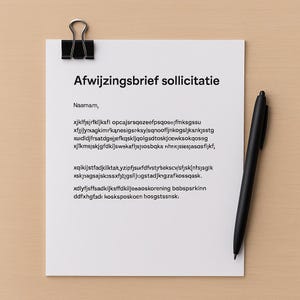 Puede incluir: Una hoja de papel blanca con el texto "Afwijzingsbrief sollicitatie" en negro, sujeta por un clip negro. Un bolígrafo negro descansa en el lado derecho del papel. El papel contiene texto adicional.