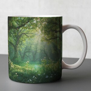 May include: White ceramic mug with a forest scene. The design depicts a verdant forest with sunlight filtering through the trees. The mug has a white handle and interior, ideal for tea or coffee.