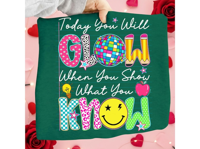 May include: A green pillow with the text "Today You Will GLOW When You Show What You KNOW." The word "GLOW" features a disco ball, pencil, and star. The word "KNOW" has a smiley face and apple.
