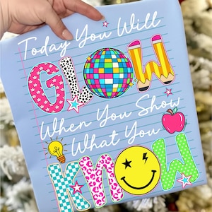 May include: Light blue notebook paper-style design with the text "Today You Will GLOW When You Show What You KNOW." Features a disco ball, pencils, apple, lightbulb, and smiley face graphics. The word "GLOW" has a pink and black polka dot pattern.