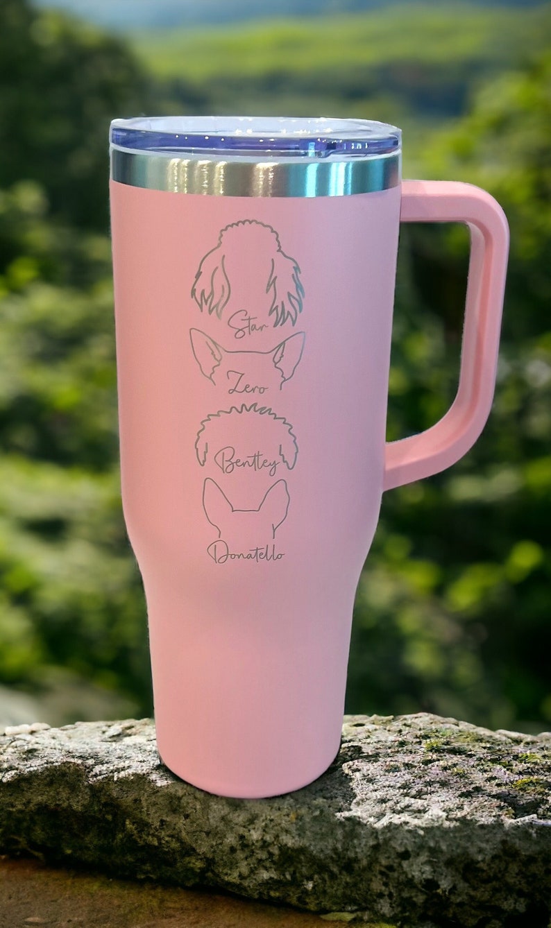 Puede incluir: Taza de viaje de acero inoxidable rosa con asa. La taza tiene una tapa plateada y est&aacute; grabada con los nombres "Star", "Zero", "Bentley" y "Donatello", junto con una silueta de un perro para cada nombre.