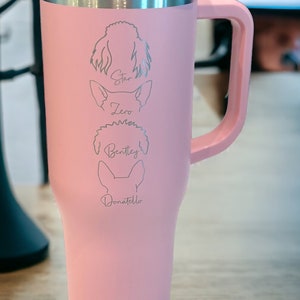 Puede incluir: Taza de viaje de acero inoxidable rosa con asa. La taza tiene una tapa plateada y est&aacute; grabada con los nombres "Star", "Zero", "Bentley" y "Donatello" junto con una silueta de cada perro.
