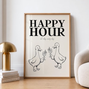 Könnte beinhalten: Ein gerahmter Kunstdruck mit dem Text "HAPPY HOUR" in fetten schwarzen Buchstaben und "all day, every day" darunter. Zwei Cartoon-Enten halten Cocktails. Der Druck ist in einem hellen Holzrahmen.