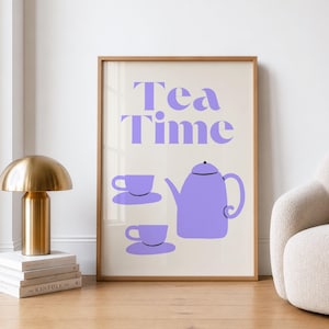 Könnte beinhalten: Ein gerahmter Druck mit den lila Worten "Tea Time", zusammen mit einer Teekanne und zwei Tassen in einem minimalistischen Stil. Das Kunstwerk befindet sich auf einem cremefarbenen Hintergrund, der in hellbraunem Holz gerahmt ist.