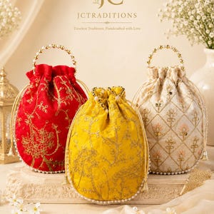 May include: Three embroidered drawstring bags in red, yellow, and cream. Each bag features intricate gold floral patterns, pearl accents, and a beaded handle. The bags are displayed on a decorative surface, with the brand name "JCTraditions" visible.