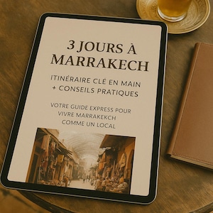 Puede incluir: Una tableta digital muestra el título "3 JOURS À MARRAKECH" en letras grandes, con texto adicional debajo. Un vaso de té con una ramita de menta está sobre un platillo dorado. También se ve un cuaderno marrón.