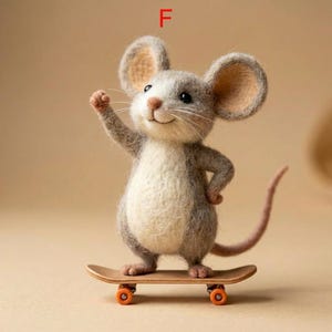 May include: A handcrafted felt mouse figure with large ears, gray and white fur, and a long tail, riding a small wooden skateboard with orange wheels. The mouse has one arm raised in a wave.