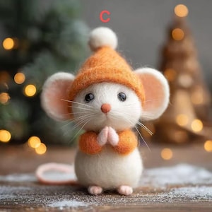 May include: A handcrafted white mouse figurine wearing an orange hat and matching mittens. The mouse has large ears, black eyes, and a pink nose. The figurine is posed with its paws together, suggesting prayer or a gesture of goodwill. The overall theme is festive and whimsical.