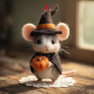 May include: A handcrafted mouse figurine wearing a black witch hat with an orange band and a matching cape. The mouse is holding a small orange pumpkin and is standing on a white lace doily. The mouse has gray and white fur.