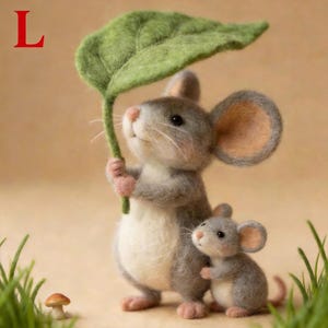 May include: A felted mouse figurine holding a large green leaf, with a smaller mouse beside it. The mice are gray and white, with pink accents on their paws and ears. A small mushroom is visible in the foreground, and the letter "L" is in the top left corner.